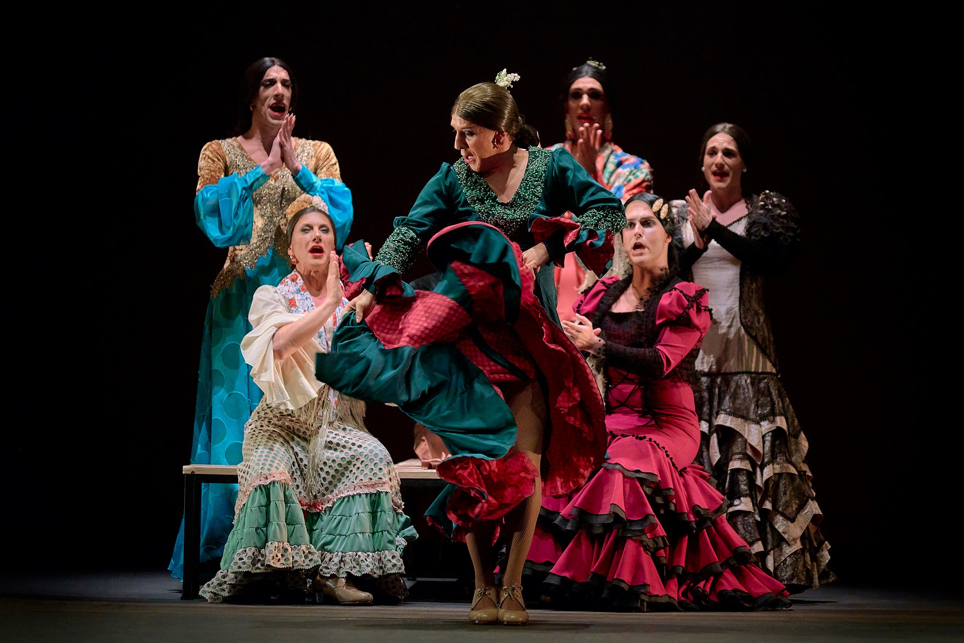 Foto van de zeven dansers van VIVA, gehuld in de traditionele bata de cola (lange sleeprok), mantón (omslagdoek), peineta (kam) spelen zij met gender.
